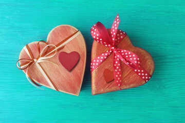 Wooden heart-shaped gift boxes on turquoise wooden background with copy space. Valentine’s day greeting