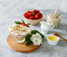 Oatmeal dessert with fresh strawberries. Healthy breakfast of strawberry parfait with fresh fruit and yogurt on a gray table. Panna Cotta. Correct, natural nutrition. Space for text. Still life