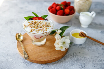 Oatmeal dessert with fresh strawberries. Healthy breakfast of strawberry parfait with fresh fruit and yogurt on a gray table. Panna Cotta. Correct, natural nutrition. Space for text. Still life