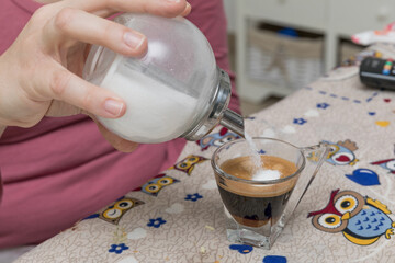 putting sugar in coffee in the morning is a ritual that allows a relaxing awakening.