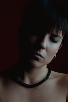 Portrait of a serious woman with her eyes closed in studio