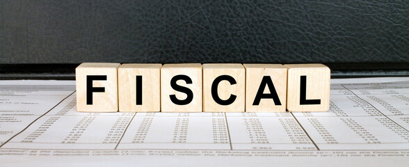 Word Fiscal made with wood toy blocks on financial tables