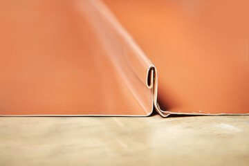 Detail of shaping sheet metal roof components in workroom