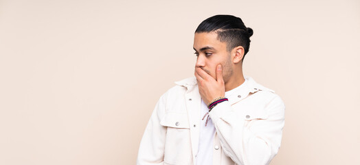 Asian handsome man over isolated background doing surprise gesture while looking to the side