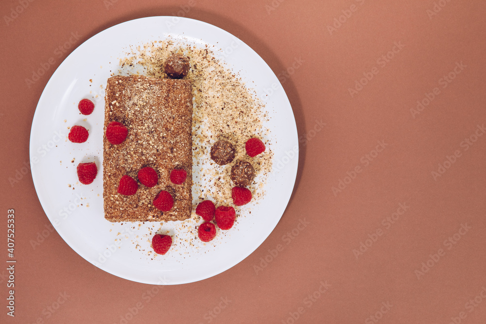 Sticker pie with honey, cocoa, nuts and raspberries. pie on a white plate . cake with honey and raspberries 