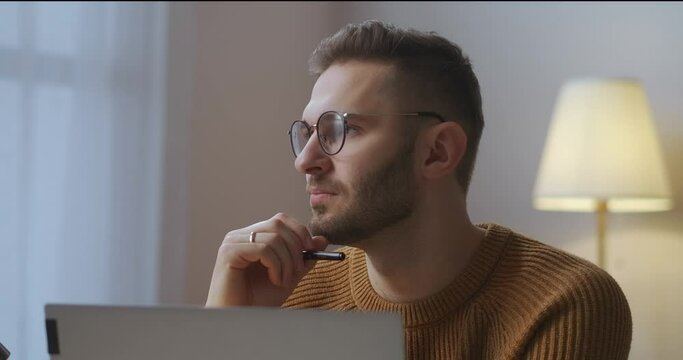 man is working on project at home, freelance and part-time job, sitting in front of notebook in room