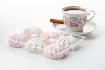 cup of hot tea marshmallow in a box cinnamon selective focus on a white background high key