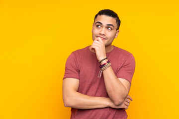 Asian handsome man isolated on yellow background extending hands to the side for inviting to come