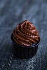Cupcakes or muffins with chocolate cream and sweets. Cake celebration, delicious dessert, close-up