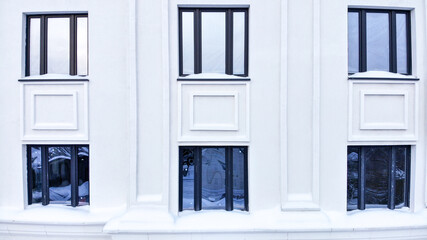 Windows of a multi-storey white building. Close angle.