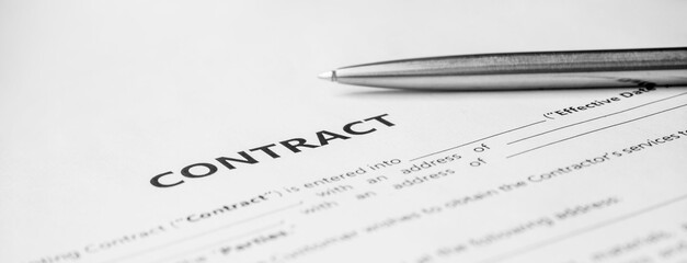 Close-up of a silver pen on docunent contract. Legal contract signing, buy sell real estate contract agreement sign on document paper with black pen