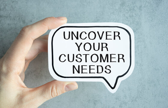 uncover your customer needs. Text on white paper in hand.