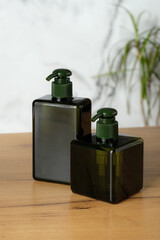 Pump dispenser bottles for shampoo or gel soap on bathroom table. Natural cosmetic packaging design