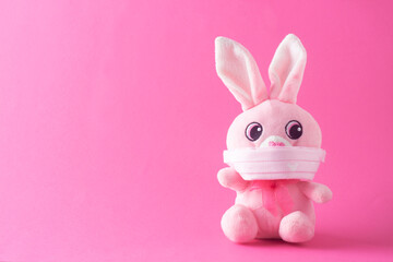 Easter rabbit with face mask - minimal concept of protection from Coronavirus. Easter holiday 2021 during Covid-19.