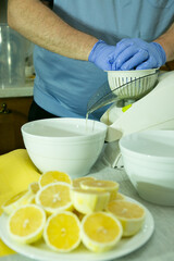 The process of making limoncello lemon liqueur at home. A man squeezes lemon juice on a food...