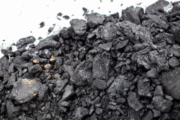 Coarse coal in the snow in winter. Maintaining high temperatures in fuel boilers, home heating systems. Combustible mineral