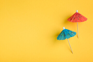 Blue and red umbrella food picks on yellow background