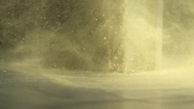 Yellow powder is thrown into a metal piece in slow motion. Yellow powder is thrown into a metal piece