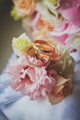 gold rings and a beautiful bridal bouquet of roses on the background. details, wedding traditions. close-up, macro