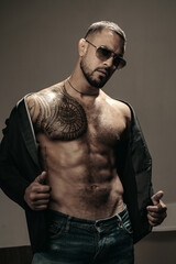 Man fashion undress. Bearded male with abs and sunglasses. Trend style macho in casual style...