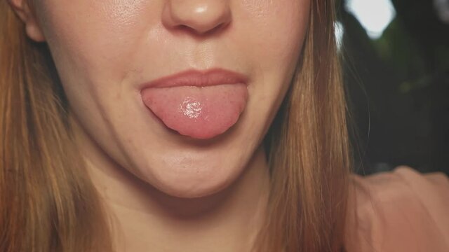 Young lady sticking out her tongue, part of the face blonde girl.