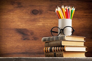 Stack of vintage books and colorful pencils on the desk
