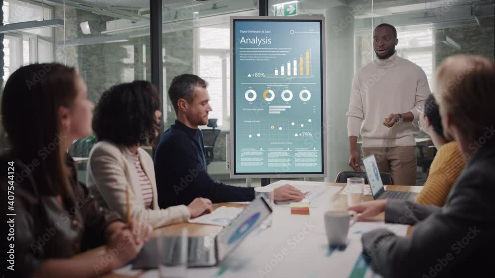 Poster project manager makes a presentation for a young diverse creative team in meeting room in an agency.