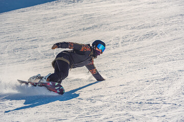 Fototapeta na wymiar Young woman snowboarder in motion on snowboard in mountains