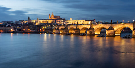 .panoramic view of Charles Bridge on the Vltava river and in the background Prague Castle and St. Vitus Cathedral in the center of Prague in the evening