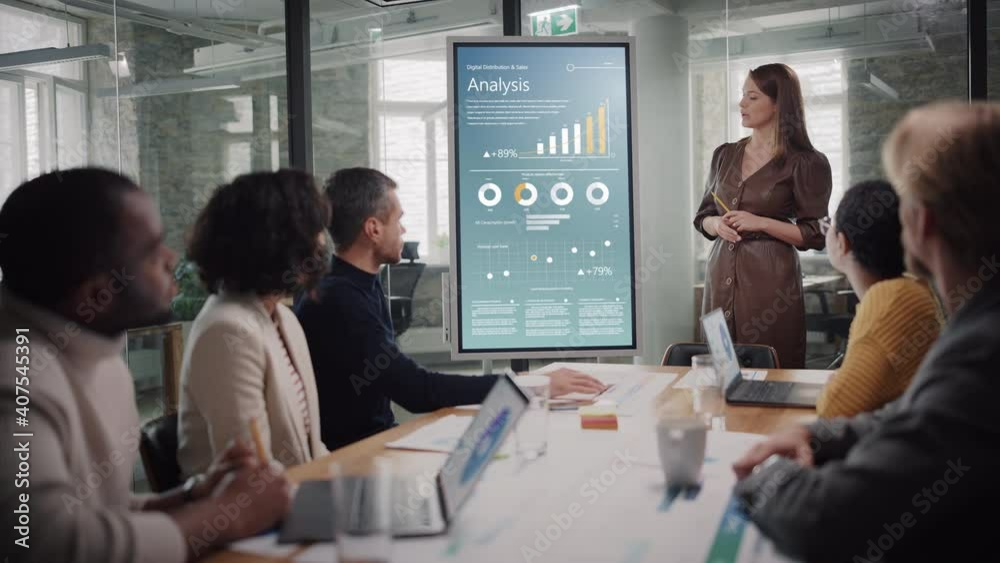 Poster project manager makes a presentation for a young diverse creative team in meeting room in an agency.