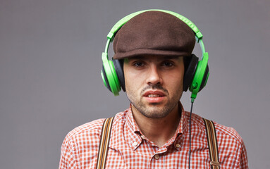 Fototapeta premium Retro music. Portrait of handsome male dj in fashionable retro styled wear and headphones. Party, music, relax concept.