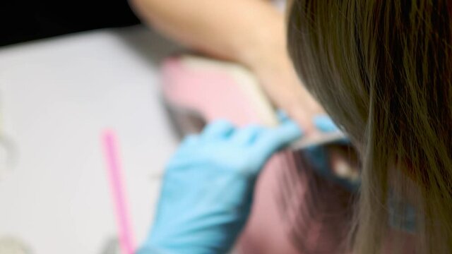 manicure buffing and filing nails to elder female customer. caucasian 50 years woman at manicure salon. beauty treatment concept.
