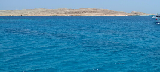 A luxury private motor yacht under way on tropical sea. Around the island on a background of the sky with clouds