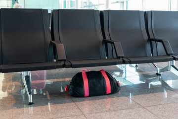 Unattended bag left under chair in the airport or bus or train station.