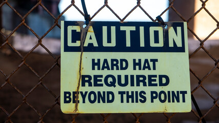 Worn out hard hat warning sign