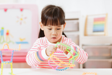 Obraz na płótnie Canvas young girl playing creative 3d shape toy for homeschooling