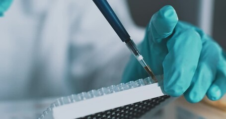Close up scientist using pipette transfer sample in micro plate - Powered by Adobe
