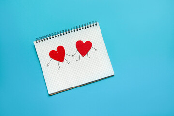 spiral notebook with two hearts holding hands