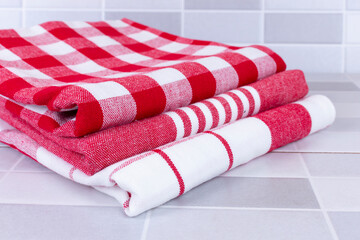 Fototapeta na wymiar Folded red checkered picnic kitchen towels on a table