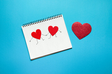 spiral notebook with two hearts holding hands
