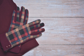 Pair of colorful pattern gloves on wooden background.  Side border from top view. Empty space for text.