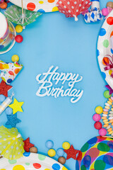 Greeting card for children's birthday with party utensils like smarties and sweets with words happy birthday
