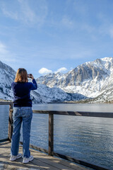 Obraz na płótnie Canvas travel woman use smart phone o taking photo of the beautiful mountain landscape.