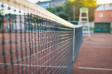 Close up of a tennis net on the court at sunset. Selective focus. Low DOF. 