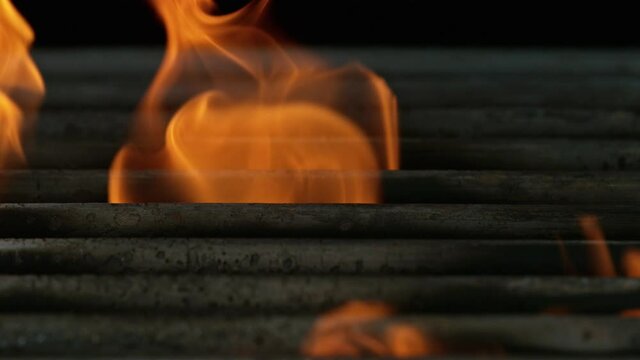 Close-up of iron cast grate with fire flames and sparks, super slow motion, filmed on high speed cinematic camera at 1000 fps.