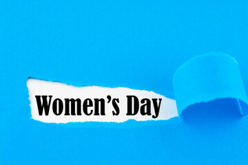 International womens day is celebrated on March 8 - text revealed by hole torn in blue paper...