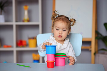 little happy toddler girl playing at the table