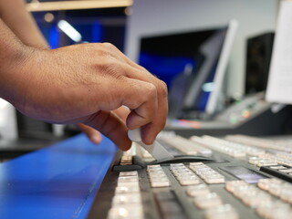 hand on dissolve of switcher buttons in studio TV station,Television Broadcast.