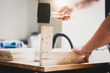 Focus on the woodwork, Entrepreneur  Woodwork holding hammer to assemble the wood pieces as the customer ordered