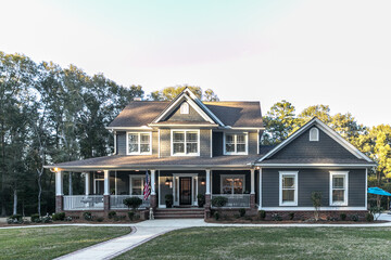 Front view of a large two story blue gray house with wood and vinyl siding